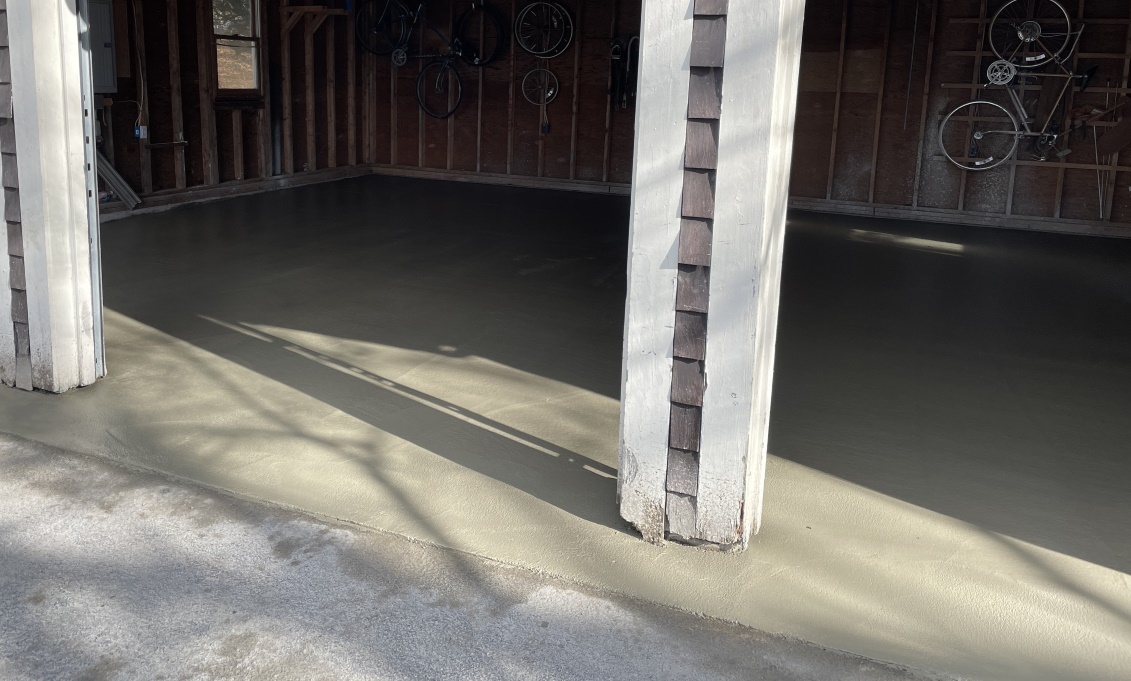 A slightly angled shot up the garage with the wet cement completed. You can see it abutting nicely with the asphalt.